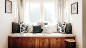 A cozy seating area with a bench, cushions, and a small stool. - Lux Casa HotTub + Sauna w/ Mtn Views, DT 10mins (Santa Fe)