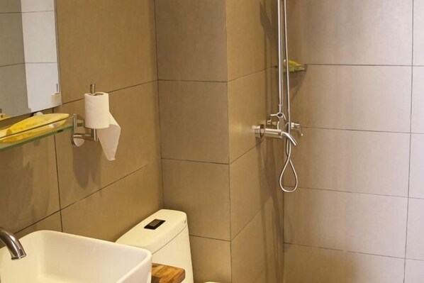 A bathroom with a toilet, a sink, a shower, and a mirror. - Sanya Mingjing Express Hotel (Sanya)