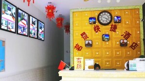 A hotel reception area with a yellow wall featuring a clock and images of destinations. - Sanya Mingjing Express Hotel (Sanya)