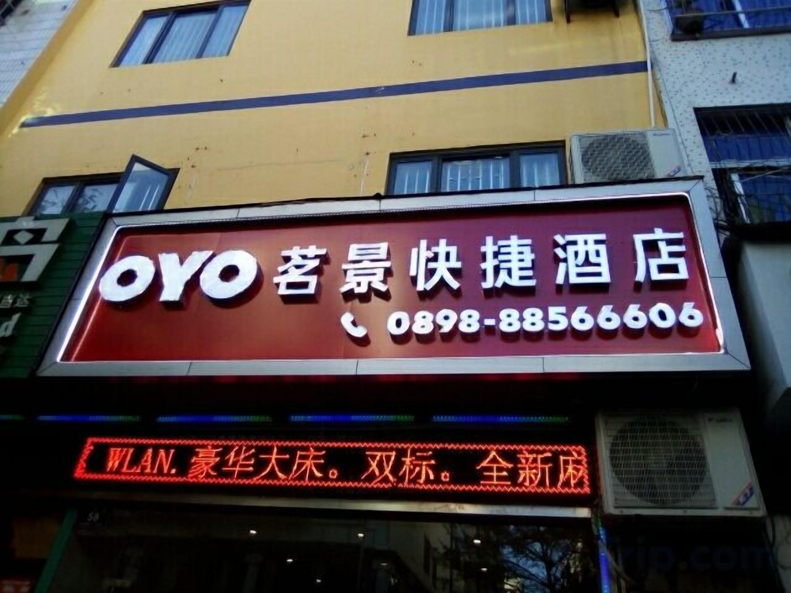 Une enseigne d’hôtel portant le nom « OYO » et un numéro de téléphone.