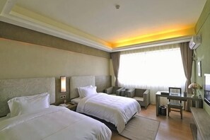 A hotel room with two beds, a desk, a chair, a small table, and a window with curtains. - Sanya Mingjing Express Hotel (Sanya)