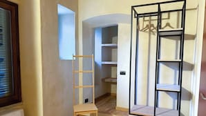 A room with a wooden ladder, a white shelf unit, and a white wardrobe. - Il Carro Rooms (Monza)