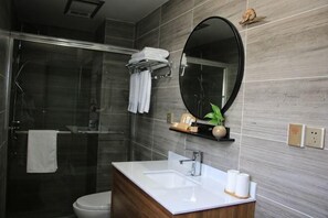 A bathroom with a glass shower enclosure, a white sink, a mirror, and a towel rack. - Taohua Island Taoyuanli Homestay (Zhoushan)