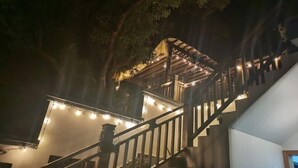 A staircase with wooden railings leading to a covered area with string lights. - Taohua Island Taoyuanli Homestay (Zhoushan)