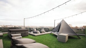 A rooftop terrace with green artificial grass, a tent, and outdoor furniture. - DISTRICT boutique  (Osijek)