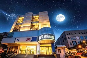 Ein Hotel mit 5G-Logo, einem Mond am Himmel und einem sternenübersäten Nachthimmel.