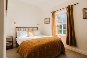 Cozy retreat with a single bed, window, and bedside table.
