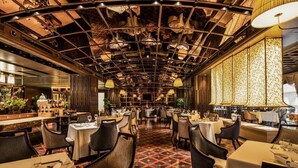 A restaurant with a high ceiling, patterned floor, and multiple dining tables and chairs. - Renhe Spring Hotel (Chengdu)