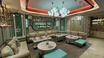 A modern lounge area with sofas, tables, and a bar.