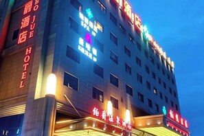 A hotel with multiple floors, illuminated signage, and a prominent entrance. - Shanghai Grand Hotel (Shanghai)