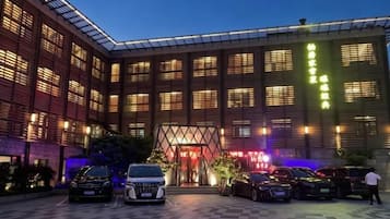 Ein Hotel mit modernem Design, das einen großen Parkplatz und einen markanten Eingang bietet.