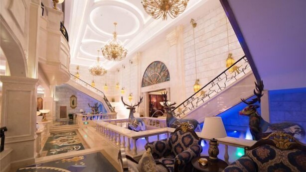 A grand lobby with a marble staircase, ornate chandeliers, and a seating area with patterned upholstery. - Shanghai Grand Hotel (Shanghai)