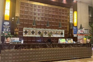 A reception area with a patterned wall, a marble counter, and pendant lighting. - Shanghai Grand Hotel (Shanghai)