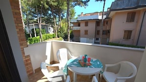 Un balcón con mesa y sillas, con vista a una zona residencial con edificios de apartamentos.