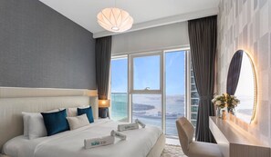 Enjoy a serene view of the sea and city from the comfort of this stylish room, featuring a large bed and a spacious window.