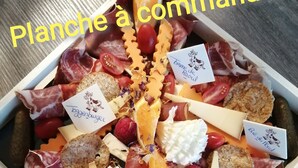 A charcuterie board with various meats, cheeses, and fruits.