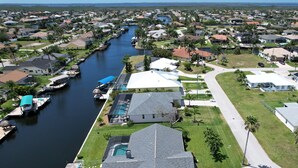 A residential area with houses, a canal, and a dock with boats.
