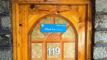 A wooden door with a glass panel and a sign above it. The sign reads "Dorm Name" and "119".