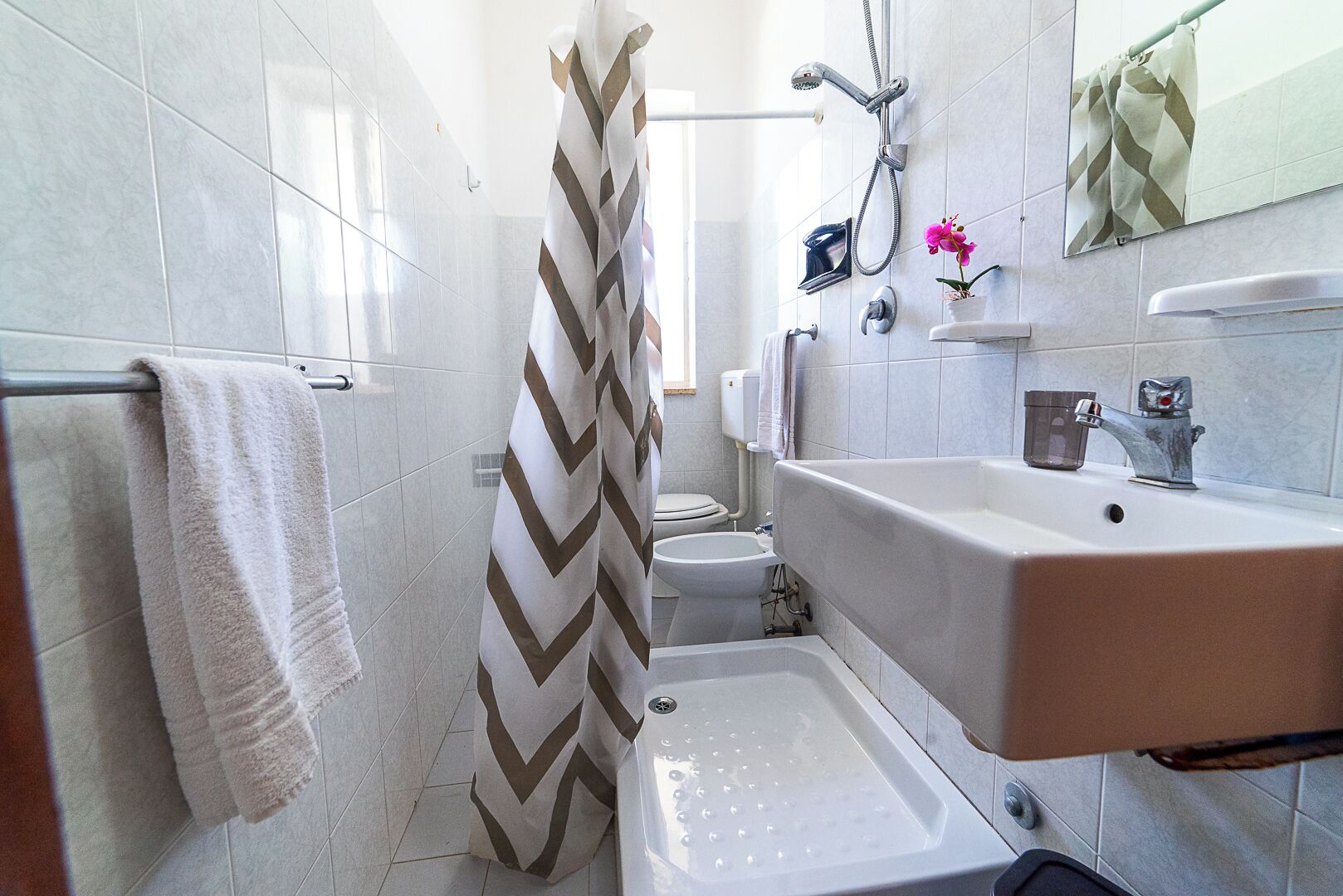 A bathroom with a shower, toilet, and sink.