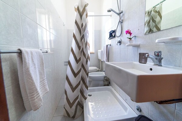A bathroom with a shower, toilet, and sink. - Residence degli Oleandri (Villanova)