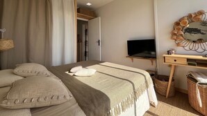 A bedroom with a bed, a TV, a desk, and a mirror. - Arcachon - 2-Bedroom Apartment with Terrace, Sea View and Parking (Arcachon)