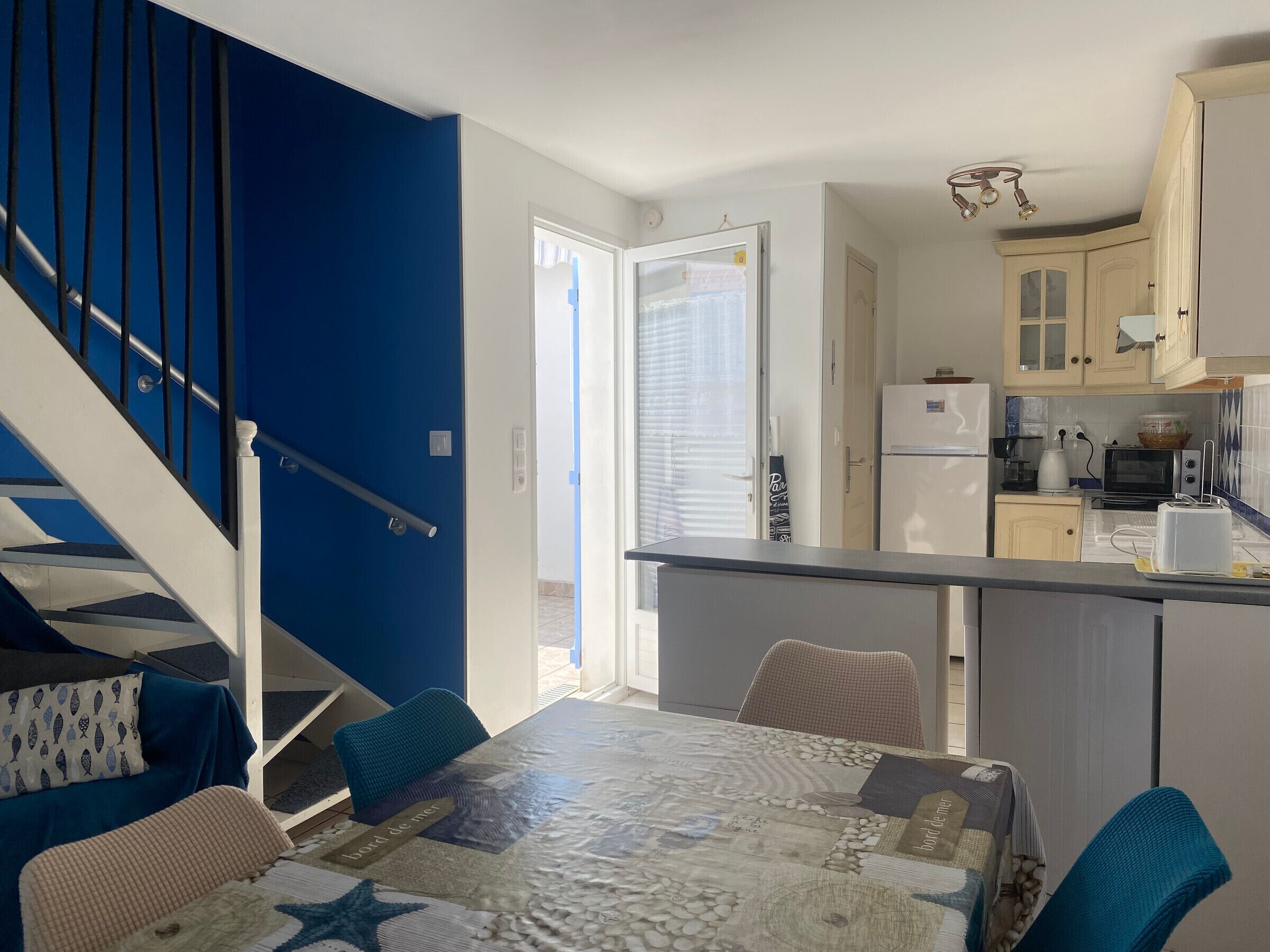 A modern kitchen with a refrigerator, microwave, and toaster.