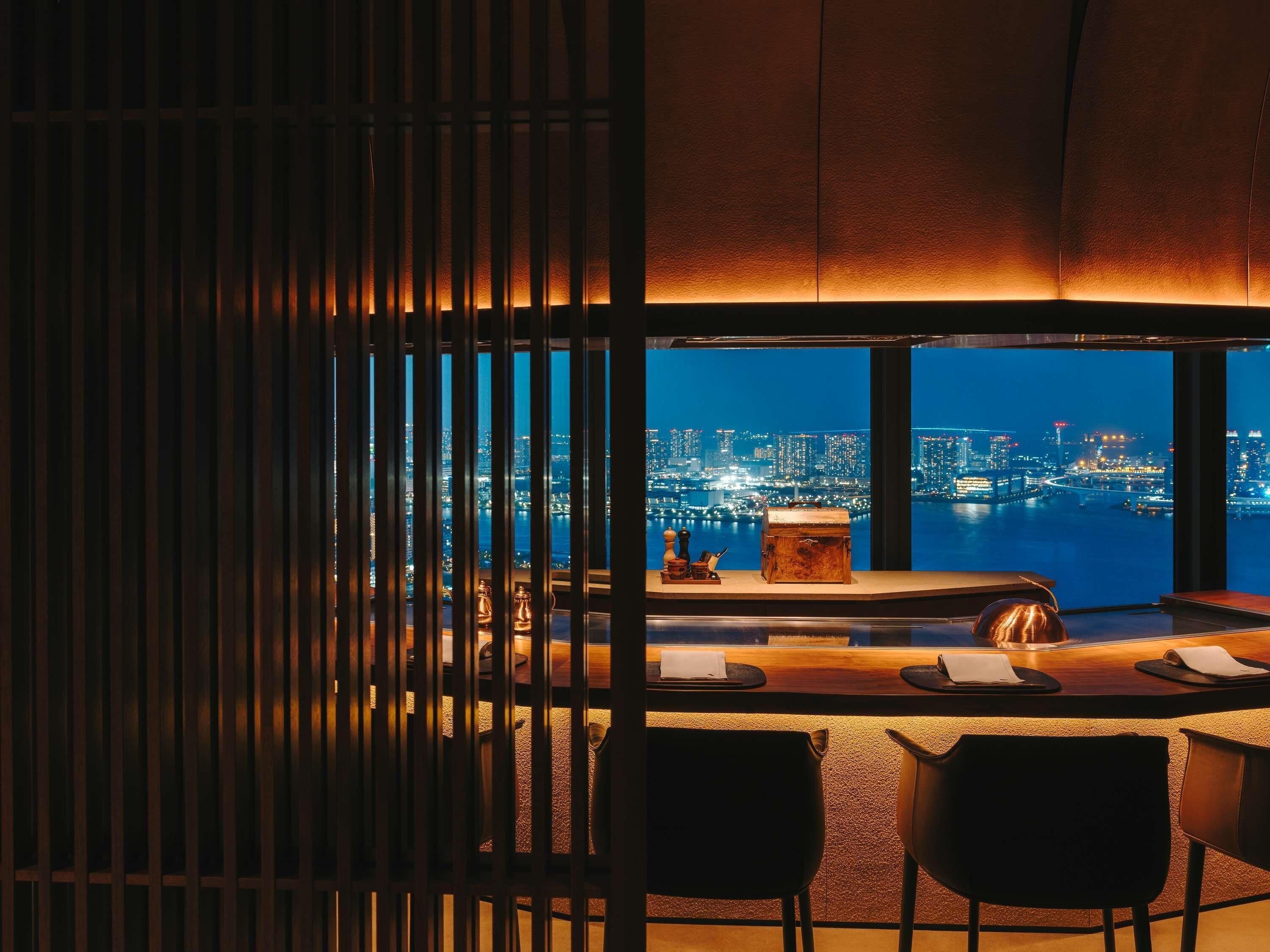 A bar with a city view, a wooden partition, and a table with chairs.
