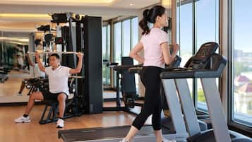 A gym with treadmills, weight machines, and a large mirror.