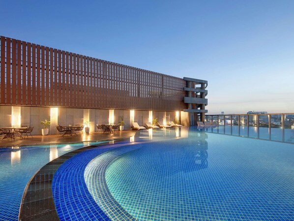 Una piscina al aire libre, sillones reclinables de piscina