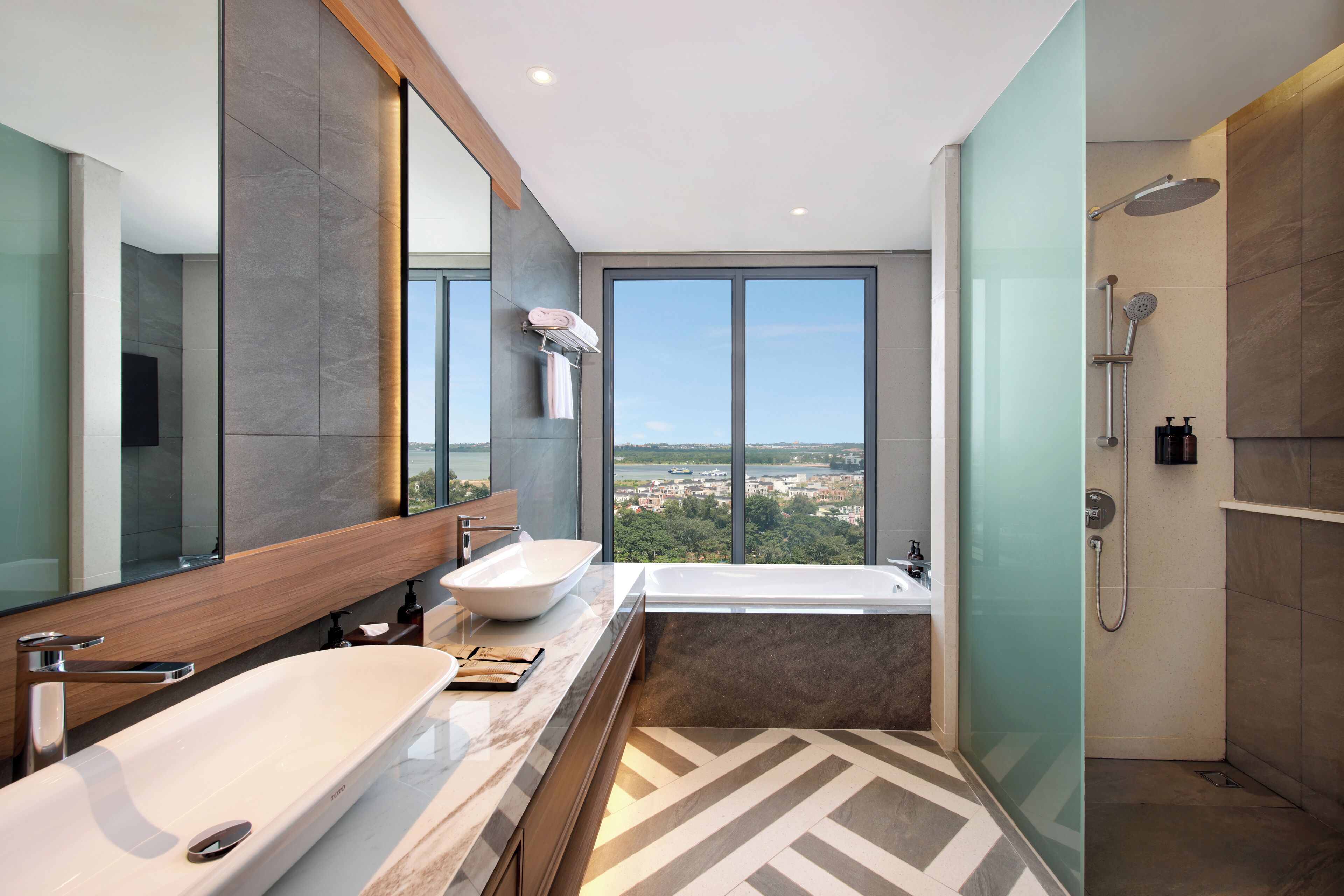 Un bagno moderno con uno specchio grande, due lavabi, una vasca e una doccia.