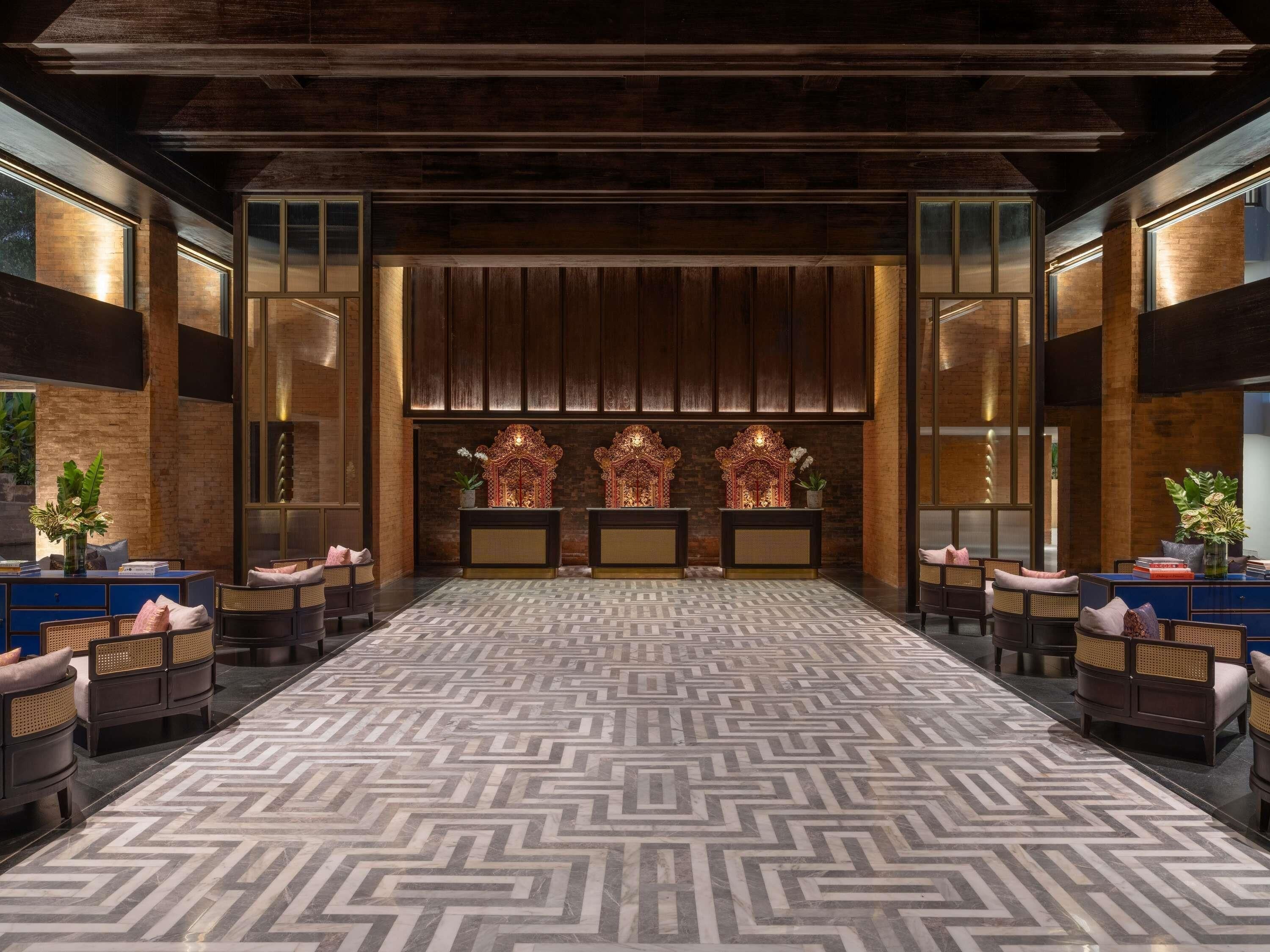 A hotel lobby with a patterned floor, seating arrangements, and decorative elements.