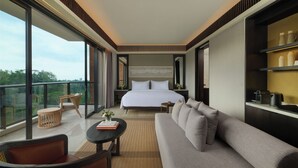 A modern hotel room with a large bed, a sofa, a small table, and a balcony with a view of the outdoors. - Novotel Bali Ubud Resort (Payangan)
