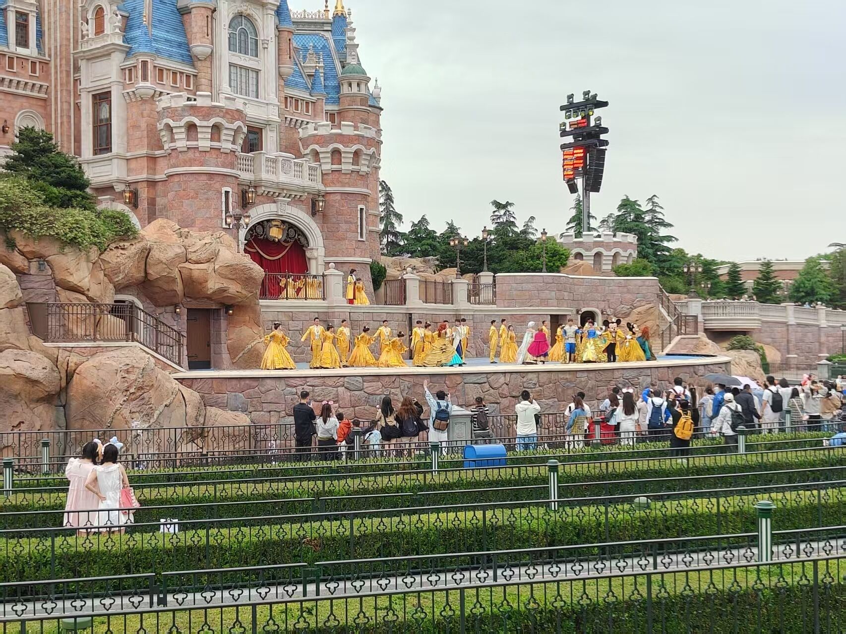 A castle-like building with a balcony and a crowd of people.
