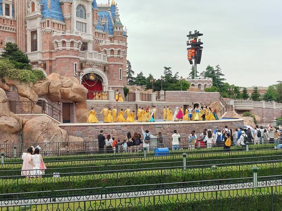 A castle-like building with a balcony and a crowd of people.