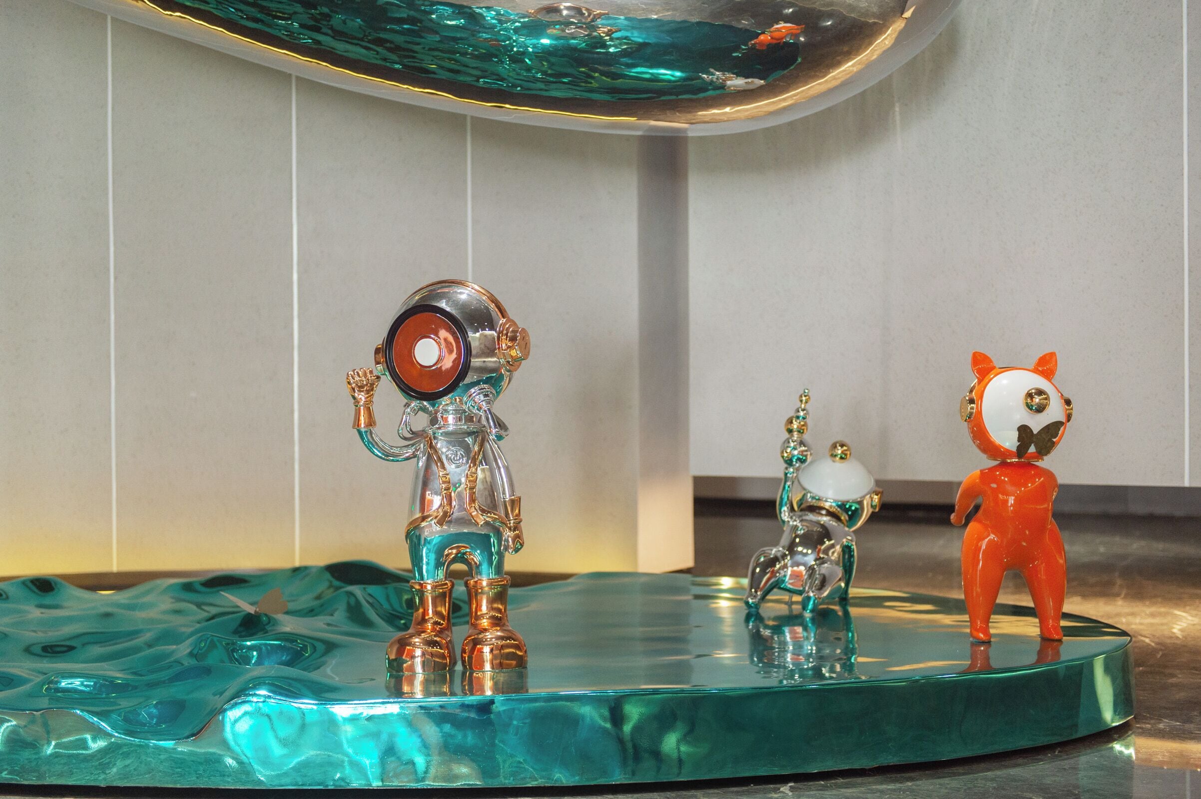 Een glazen tafel met drie decoratieve beeldjes.