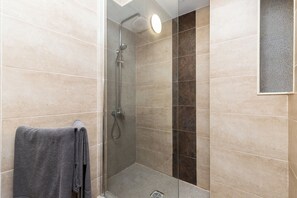 Een douche, een haardroger, handdoeken, toiletpapier