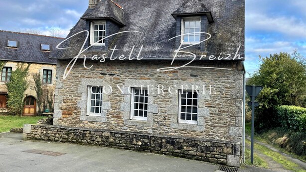 A stone building with a steeply pitched roof and multiple windows. - Le Gîte des Sabotiers by Kastell Breizh (Canihuel)