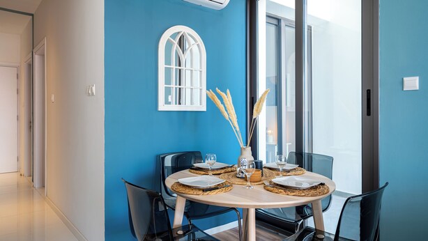 A dining area with a round table, chairs, and a window with a view. - Hue 1-Bedroom Apartment in Larnaca (Larnaca)