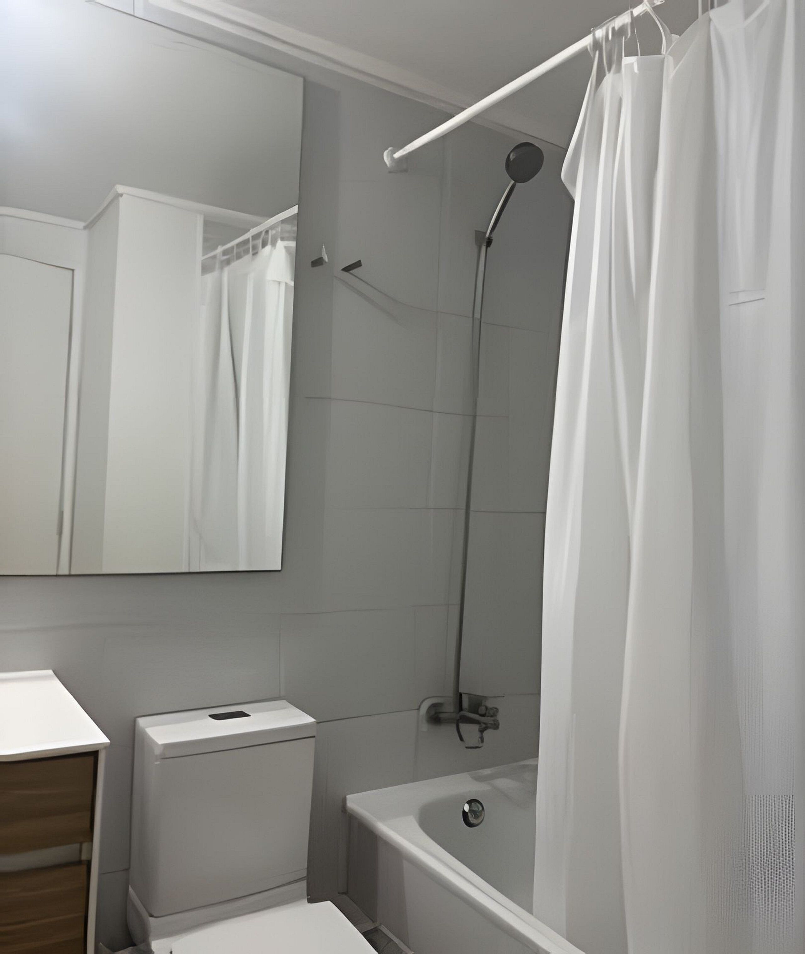 A bathroom with a toilet, sink, mirror, shower, and bathtub.