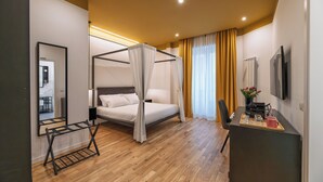 Un dormitorio moderno con una cama con dosel, un escritorio con bandeja y un espejo grande.