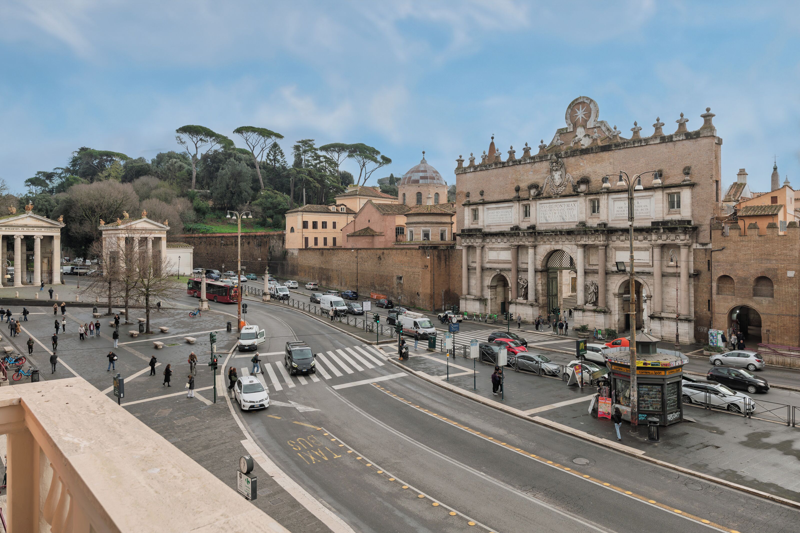 A busy urban street with historic buildings, a tram, and pedestrians.