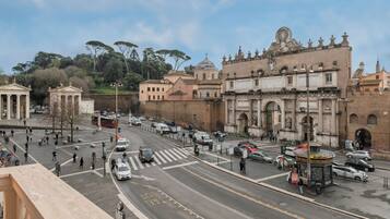 A busy urban street with historic buildings, a tram, and pedestrians.