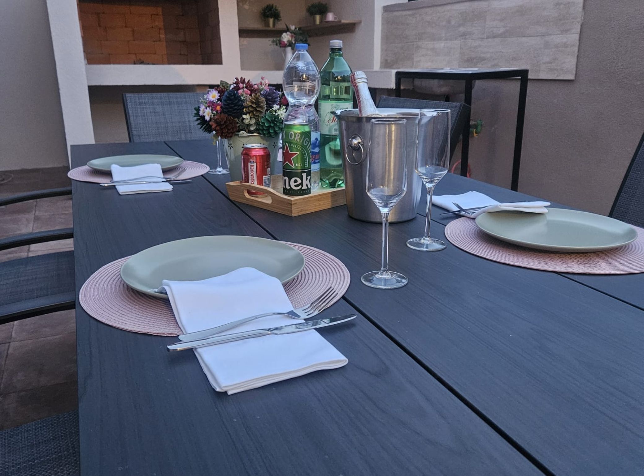 Une table à manger dressée avec des assiettes, des couverts et une bouteille de bière.