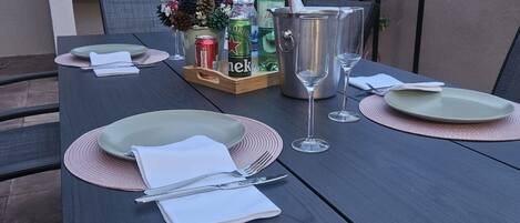 Une table à manger dressée avec des assiettes, des couverts et une bouteille de bière.
