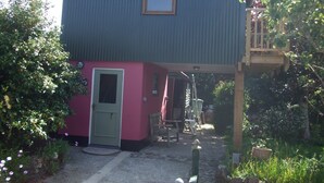 A two-story building with a red lower section and a grey upper section. - Quiet retreat in rural Cornish garden. (Truro)