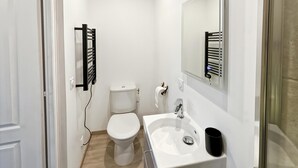 A small, clean bathroom with a white toilet, a sink, and a mirror. - Studio Horizon Bleu (5-minute walk from the sea) (Criel-sur-Mer)