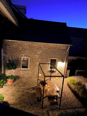 A stone building with a wooden table and benches in the courtyard. - Vacation home * Atmospheric * Luxury * - 3 spacious bedrooms, each with private bathroom (Nuth)