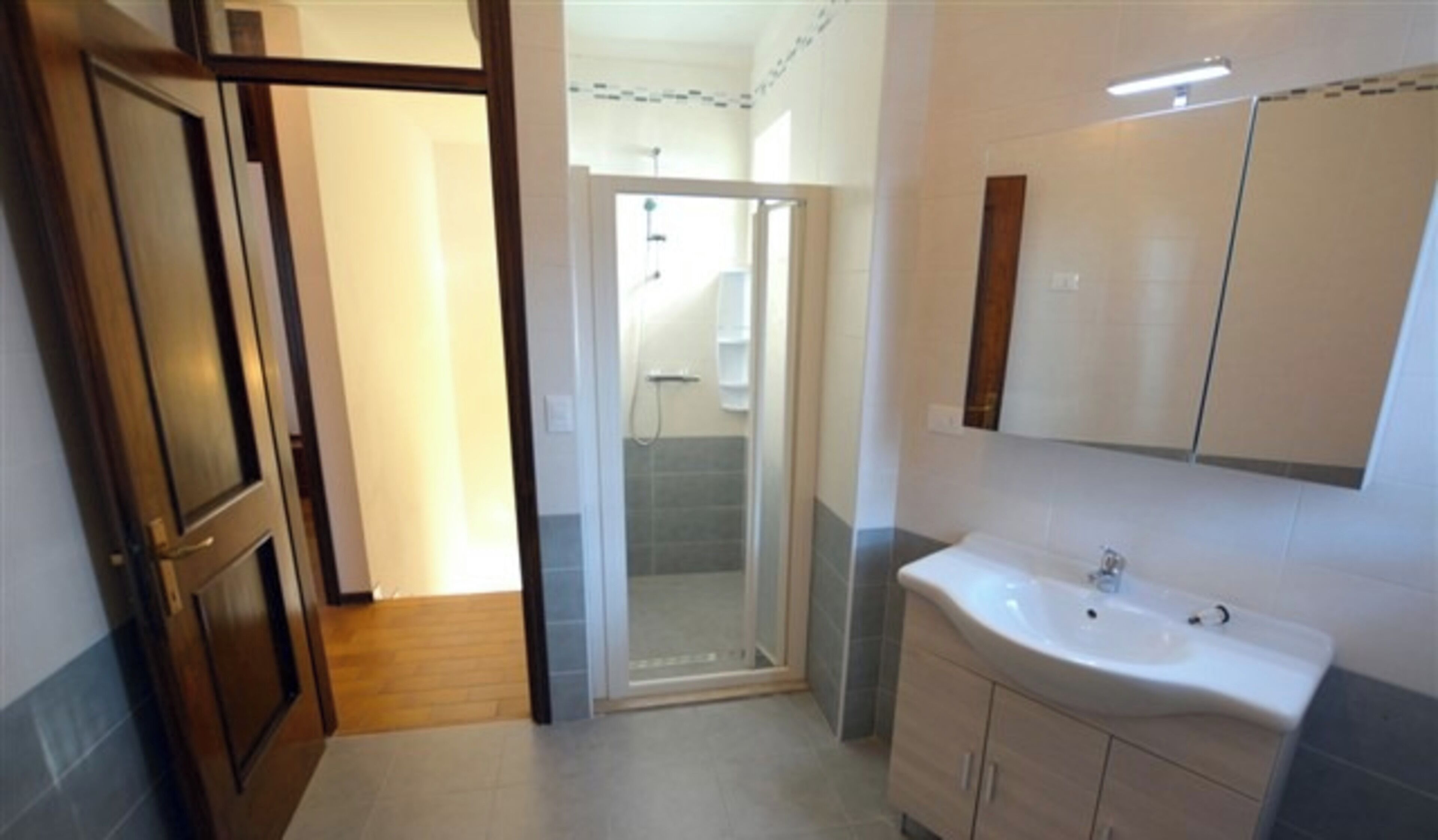 A bathroom with a shower, a sink, and a mirror.