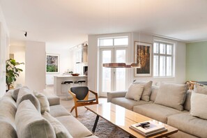 Un salon moderne comprenant un canapé, une table basse et un coin repas avec des chaises et une table.