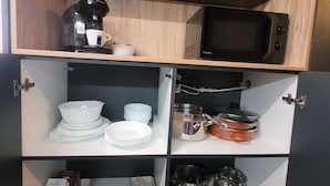 Keittiössä on mikroaaltouuni, kahvinkeitin sekä erilaisia astioita ja keittoastioita.